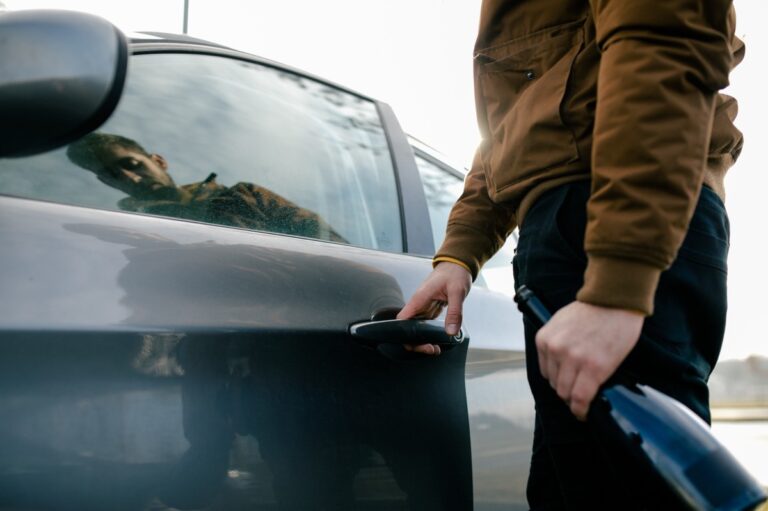 MPU-relevante Situation: Mann steigt in ein Auto, während er eine offene Flasche Wein in der Hand hält